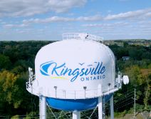 Kingsville water tower with town name and logo against blue sky